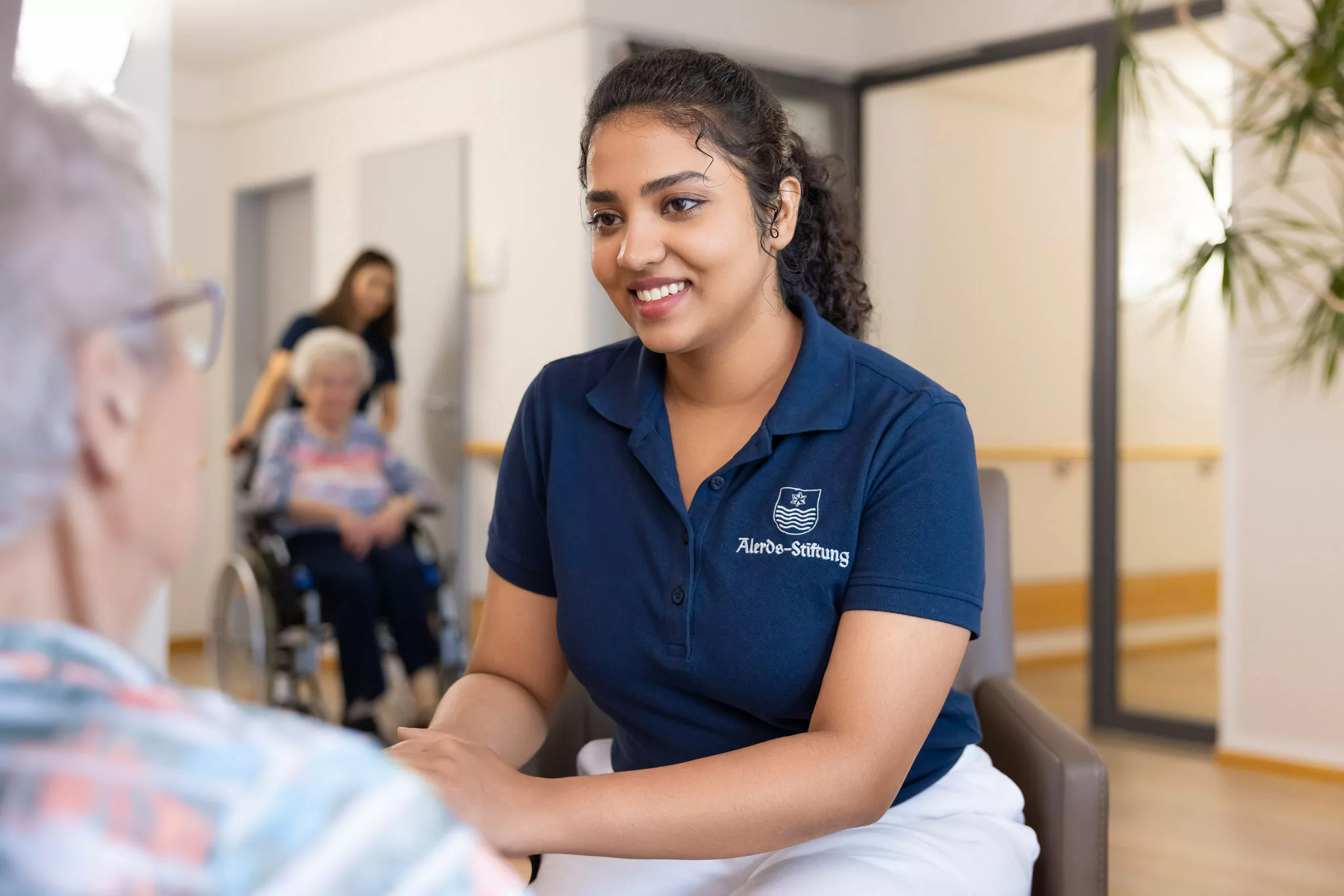 Arbeiten Sie in einer visionären Einrichtung mit Tradition Pflegekraft hält die Hand einer Seniorin
